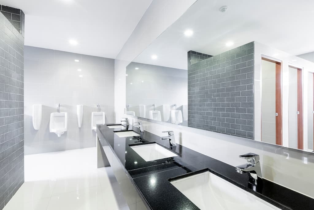 Modern office bathroom renovation in Sydney with black granite benchtop and grey brick tiles