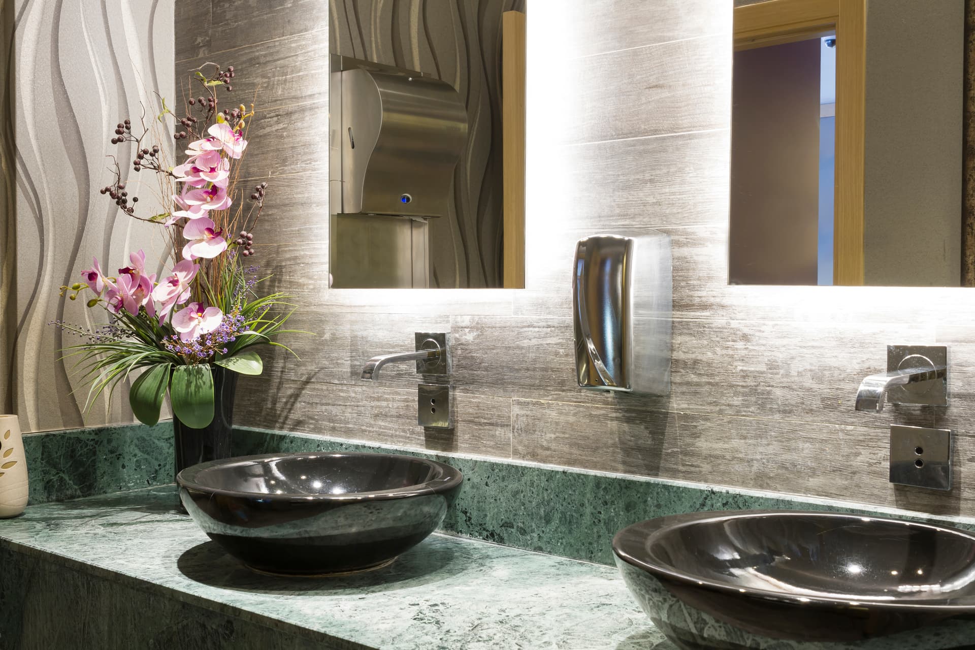 Commercial bathroom renovation in Sydney with green marble benchtop, vessel basins and backlit mirrors